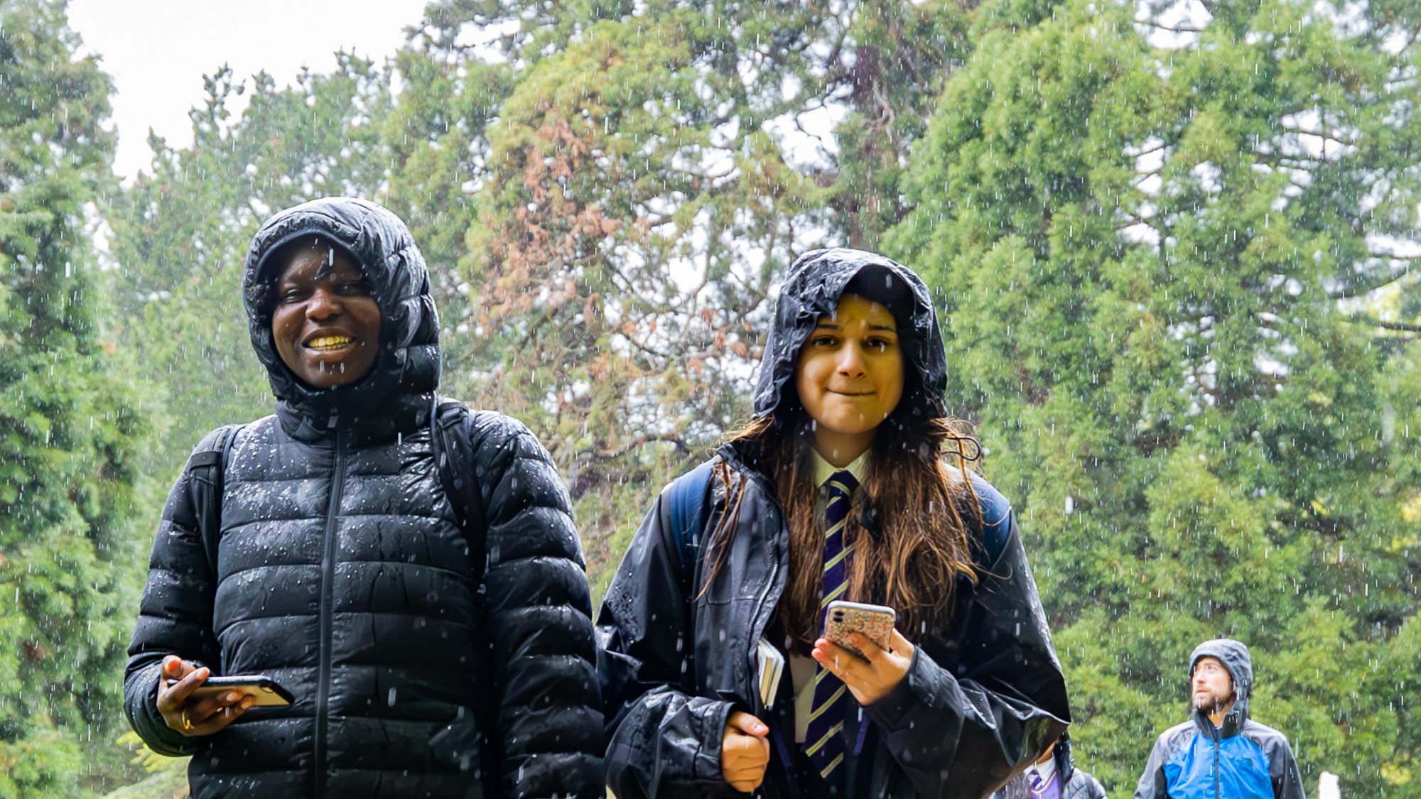 Children in the rain walking through a garden