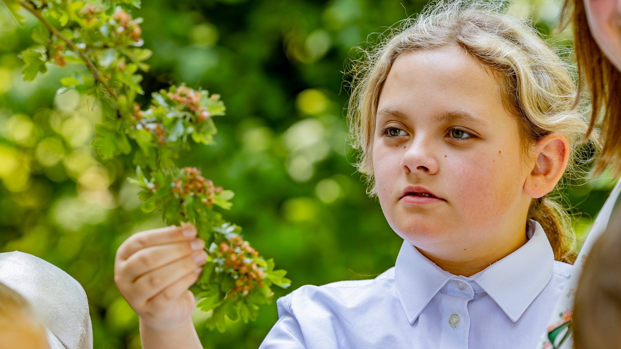 Blond Girl holding a hawthorn leaf