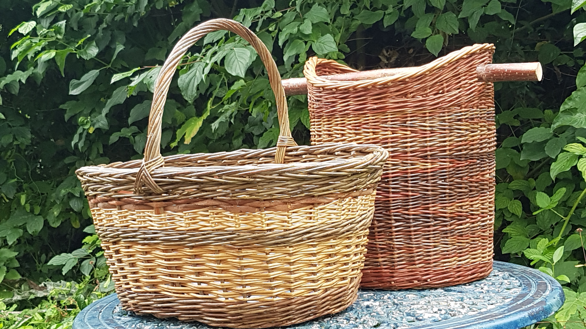 Two hand woven baskets on a garden table