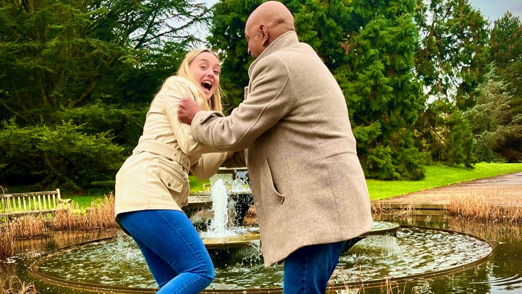 Raj Bisram pretending to push his co-presenter, Hettie Jago, into the CUBG fountain