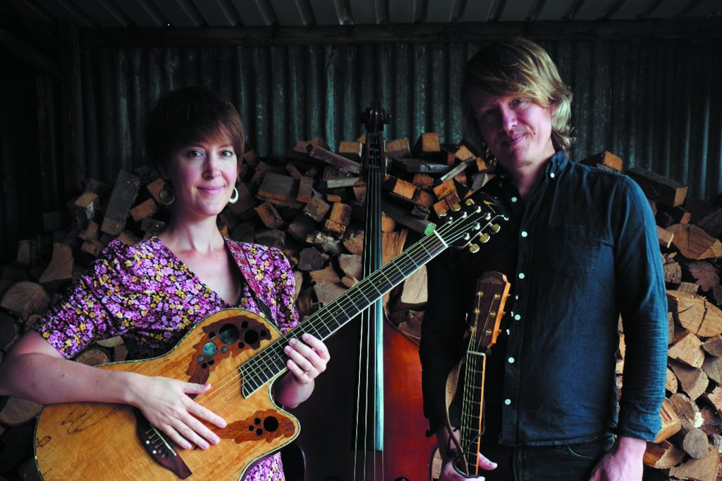 Duo of a male and a female performers holding guitars